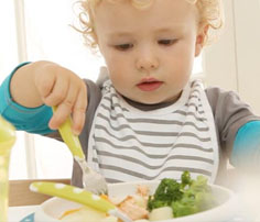 [Translate to Spanish:] kids eating and drinking