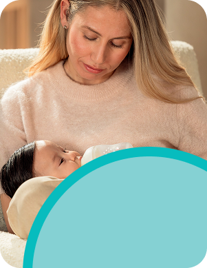 [Translate to Spanish (Reborn):] Mother with baby and baby bottle